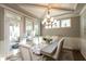 Dining room with view of an enclosed porch, a decorative table runner, and a chandelier at 3982 Abbotsford Dr, Westfield, IN 46074