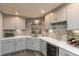Stylish wet bar area featuring stone backsplash, gray cabinets, wine cooler, and barware storage at 3982 Abbotsford Dr, Westfield, IN 46074