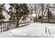Backyard deck covered in snow with a view of a house and garage behind the fence at 5937 Broadway St, Indianapolis, IN 46220