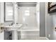 A clean white bathroom offers a shower-tub combo and a pedestal sink at 5937 Broadway St, Indianapolis, IN 46220