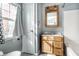 This bathroom features a wooden vanity with marble top, a window and a white door at 5937 Broadway St, Indianapolis, IN 46220