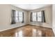 An empty bedroom with hardwood floors and two windows offers plenty of natural light at 5937 Broadway St, Indianapolis, IN 46220