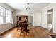Dining room featuring hardwood floors, chandelier, and antique cabinet with a large window at 5937 Broadway St, Indianapolis, IN 46220