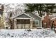 Charming two-story home featuring a covered porch and manicured front yard during winter at 5937 Broadway St, Indianapolis, IN 46220