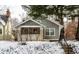 Charming two-story home featuring a covered porch and manicured front yard during winter at 5937 Broadway St, Indianapolis, IN 46220