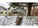 Charming two-story home featuring a covered porch and manicured front yard during winter at 5937 Broadway St, Indianapolis, IN 46220