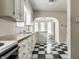 Kitchen with white cabinets, butcher block countertops, and black and white checkered floors at 5937 Broadway St, Indianapolis, IN 46220