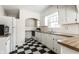 Kitchen with white appliances, black and white checkered floors, and butcher block countertops at 5937 Broadway St, Indianapolis, IN 46220