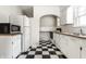 Kitchen featuring white appliances, black and white checkered floors and butcher block countertops at 5937 Broadway St, Indianapolis, IN 46220