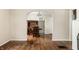 Living room with hardwood floors, arched doorway and view into dining room with built-in cabinet at 5937 Broadway St, Indianapolis, IN 46220