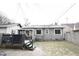 View of the home's gray siding and dark deck overlooking a snow dusted lawn at 6047 Guilford Ave, Indianapolis, IN 46220