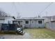 View of the home's gray siding and dark deck overlooking a snow dusted lawn at 6047 Guilford Ave, Indianapolis, IN 46220