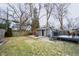 View of home's backyard showing green grass, detached garage and an outdoor firepit at 6047 Guilford Ave, Indianapolis, IN 46220