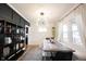 Dining room with dark accent wall, modern chandelier, and natural light from surrounding windows at 6047 Guilford Ave, Indianapolis, IN 46220