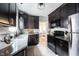Modern kitchen featuring dark cabinetry, stainless steel appliances, and sleek countertops at 6047 Guilford Ave, Indianapolis, IN 46220