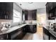 Well-lit kitchen features granite counters, stainless steel appliances, dark wood cabinets, tile backsplash, and tiled floors at 6047 Guilford Ave, Indianapolis, IN 46220