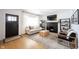Open living area showcasing a large window, brick fireplace, ceiling fan, and hardwood flooring at 6047 Guilford Ave, Indianapolis, IN 46220