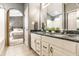Bathroom featuring double sinks with granite countertops, white cabinetry, and an arched doorway at 6432 Hunters Green Ct, Indianapolis, IN 46278