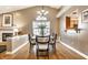 Elegant dining room with modern chandelier, fireplace, and large window for abundant natural light at 6432 Hunters Green Ct, Indianapolis, IN 46278