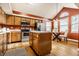 Bright, open kitchen with wood cabinets, modern appliances, and a center island with additional storage at 6432 Hunters Green Ct, Indianapolis, IN 46278