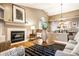 Warm living room with a cozy fireplace, wicker furniture, and an open view to the adjacent dining area at 6432 Hunters Green Ct, Indianapolis, IN 46278