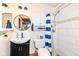 Updated bathroom with a dark vanity, patterned tiling, and a walk-in shower with blue striped curtain at 7344 Quartz Rock Rd, Indianapolis, IN 46236