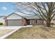 Charming brick home featuring a well-kept lawn, attached garage, and beautiful tree in front at 7344 Quartz Rock Rd, Indianapolis, IN 46236