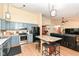 Modern kitchen with blue cabinets, stainless steel appliances, island with seating, and wood laminate flooring at 7344 Quartz Rock Rd, Indianapolis, IN 46236