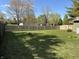 Large, fenced-in backyard features a well-maintained lawn, offering privacy and plenty of space for outdoor activities at 7824 Inverness Dr, Indianapolis, IN 46237