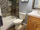 Bathroom with a mosaic tile shower, oak vanity, and modern fixtures at 7824 Inverness Dr, Indianapolis, IN 46237