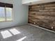 Well-lit bedroom featuring a wood accent wall, neutral carpeting, and a bright window at 7824 Inverness Dr, Indianapolis, IN 46237