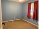 Bedroom with a window dressed with red curtains and neutral carpeted flooring at 7824 Inverness Dr, Indianapolis, IN 46237