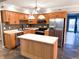 Well-equipped kitchen featuring an island, stainless steel refrigerator, oak cabinets and mosaic tile backsplash at 7824 Inverness Dr, Indianapolis, IN 46237