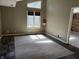 Sunlit living room with a textured rug, large window, and a door leading to a room with wood paneling at 7824 Inverness Dr, Indianapolis, IN 46237