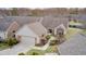 Aerial view of brick home with two-car garage, bay window, and decorative landscaping at 8545 Olde Ml Trce, Indianapolis, IN 46260