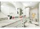 Bright bathroom with dual sinks, granite countertop, vanity seating, and sleek black and white design at 8545 Olde Ml Trce, Indianapolis, IN 46260