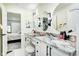 Bright bathroom with dual sinks, granite countertop, vanity seating, and access to ensuite bedroom at 8545 Olde Ml Trce, Indianapolis, IN 46260
