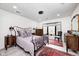 Cozy bedroom featuring an iron bed frame, natural light from window, dresser, and warm rug at 8545 Olde Ml Trce, Indianapolis, IN 46260