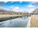 Scenic view of the community with pond reflections, lush landscaping, and well-maintained exteriors at 8545 Olde Ml Trce, Indianapolis, IN 46260