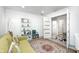 Inviting home office features a comfortable olive couch, chair, bookshelf, and doorway view to a tiled hallway at 8545 Olde Ml Trce, Indianapolis, IN 46260