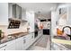 Modern white kitchen with granite countertops, stainless steel appliances and black and white backsplash accent at 8545 Olde Ml Trce, Indianapolis, IN 46260
