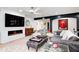 Modern living room features a fireplace, TV, ceiling fan, elegant seating, and an entryway view at 8545 Olde Ml Trce, Indianapolis, IN 46260
