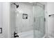 Modern shower featuring marble-look tile, a built-in niche, bathtub, and sleek glass door at 8545 Olde Ml Trce, Indianapolis, IN 46260