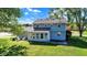 Spacious backyard featuring the home, a sunroom, lush lawn, mature trees, and patio seating at 908 Whispering Trl, Greenfield, IN 46140