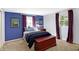 Bedroom with blue walls, a patterned carpet, and natural light from two windows at 908 Whispering Trl, Greenfield, IN 46140