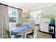 Cozy dining room features a mural, chandelier, wood table with seating for four and view to the kitchen at 908 Whispering Trl, Greenfield, IN 46140