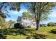 Two-story home with light gray siding, a well-manicured lawn, and a tree-lined yard at 908 Whispering Trl, Greenfield, IN 46140