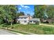 Charming two-story home with a brick chimney, well-manicured lawn, mature trees, and a welcoming yellow front door at 908 Whispering Trl, Greenfield, IN 46140