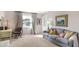 Bright living room features a large window, neutral decor, desk, and comfortable seating at 908 Whispering Trl, Greenfield, IN 46140