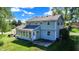 View of the home's back exterior with an enclosed sunroom and access to a grassy backyard area at 908 Whispering Trl, Greenfield, IN 46140